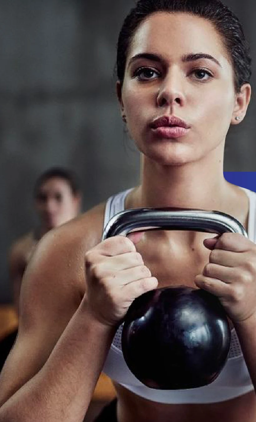 A woman holding a kettlebell, ready to train